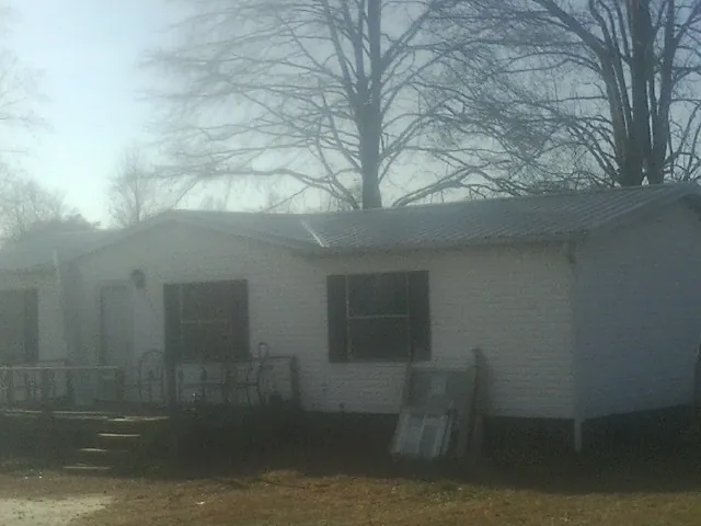 New metal roof on a white painted brick home on a foggy morning in Cambria Heights