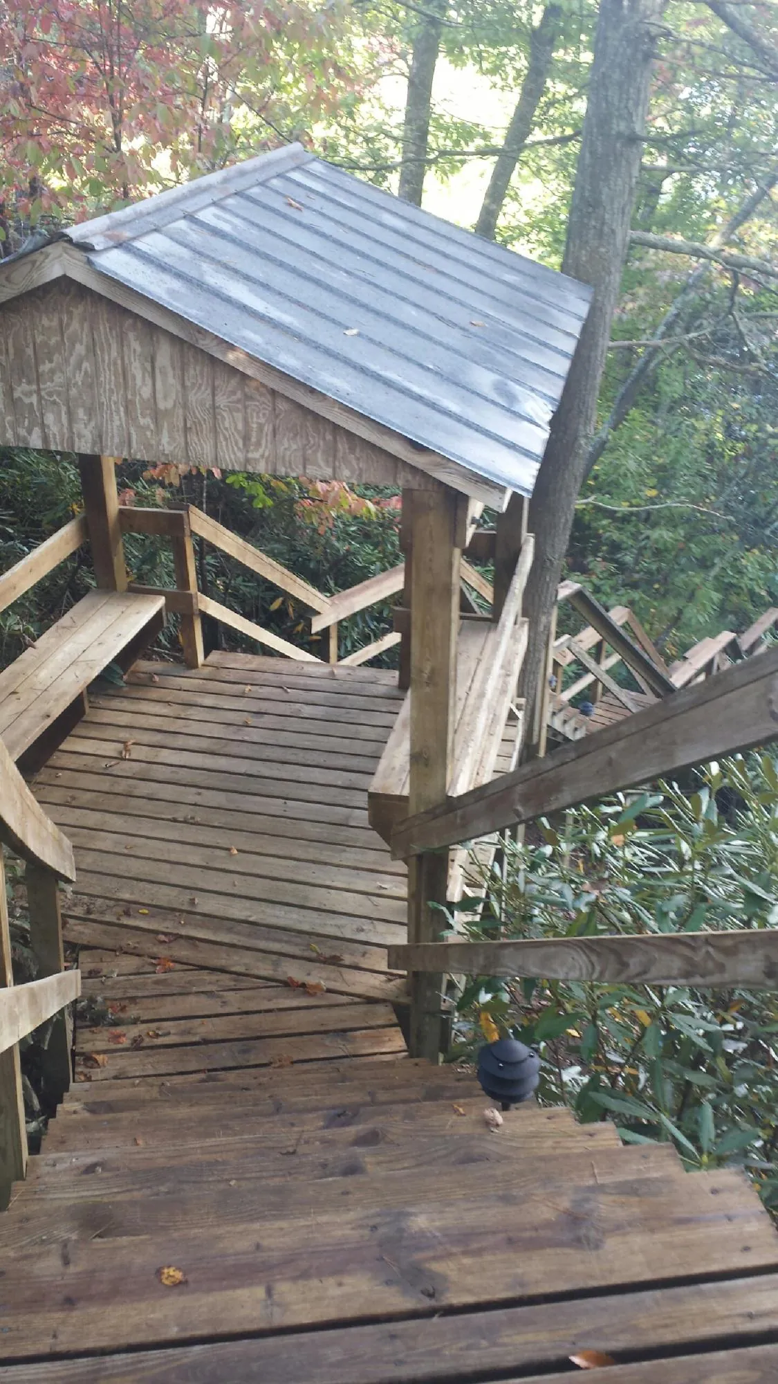 Metal roofed shelter over wooden steps on a wooded walkway — Skylight Repair & Installation work by our crew in Cambria Heights