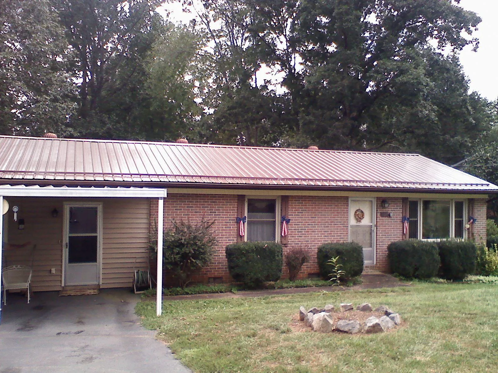 Bronze metal roof and carport on a brick ranch home — Roof Repair work by our crew in Cambria Heights